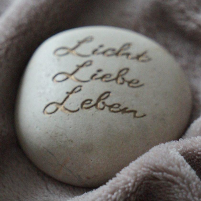 Stein mit Gravur 'Licht Liebe Leben' als Symbol für Reiki-Werte